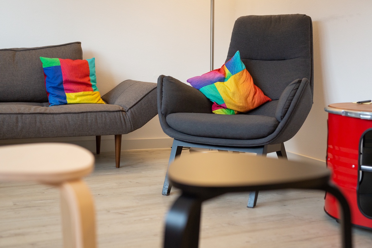 Behandlungsraum 2 – Detailansicht mit Sessel, Sofa und Hockern